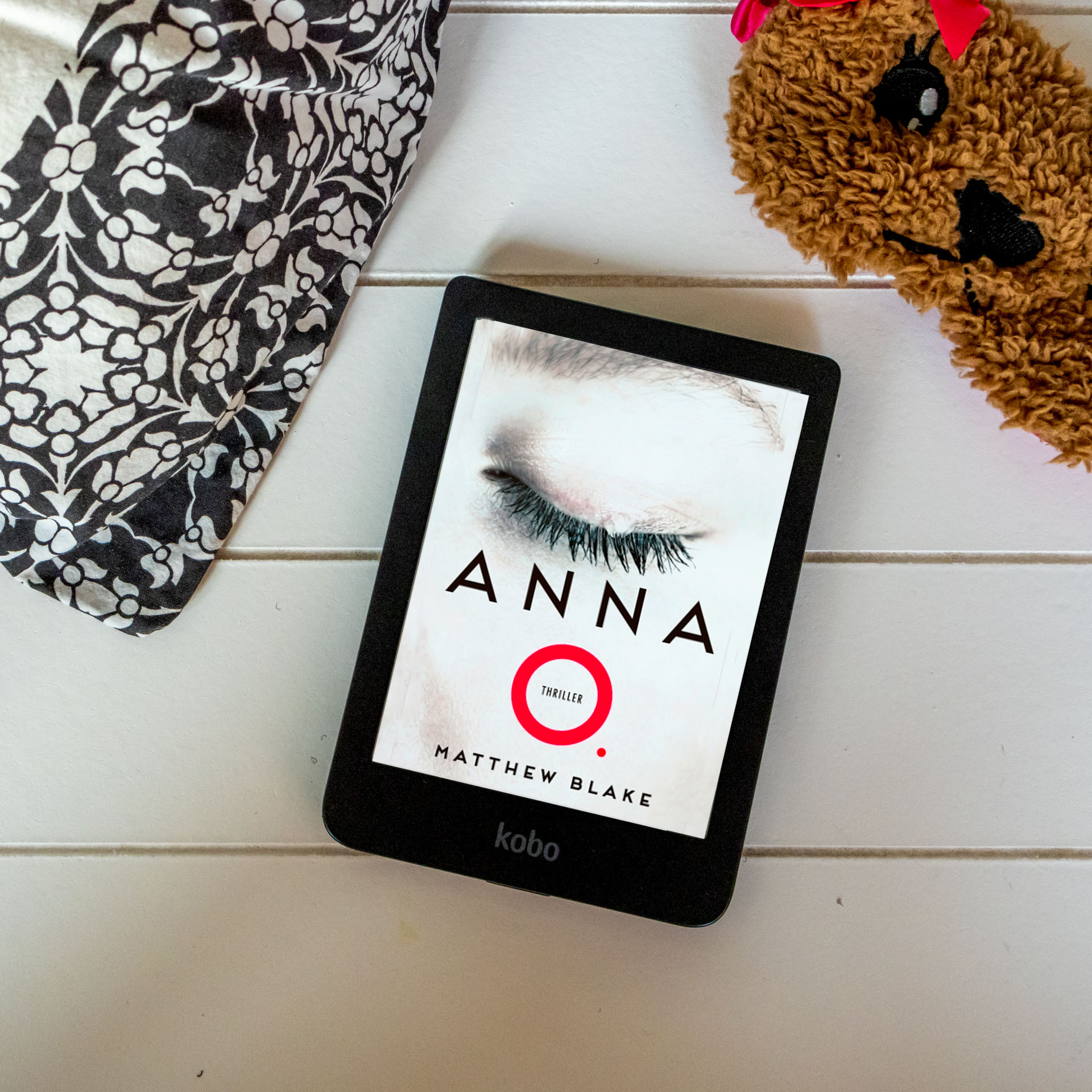 Witte achtergrond met e-reader van Kobo met boek Anna O. van Matthew Blake erop